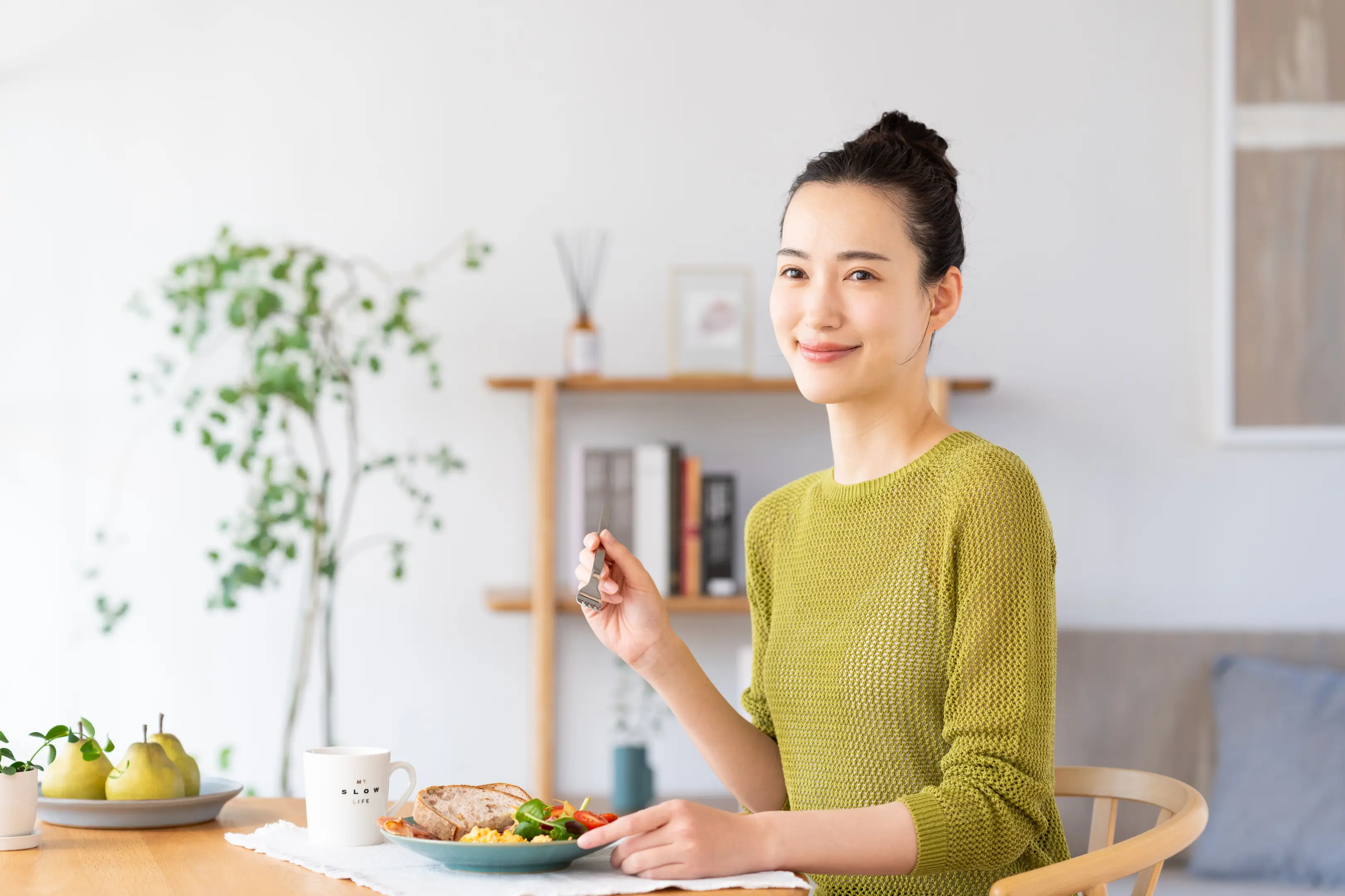 食事を食べながら微笑んでいる女性